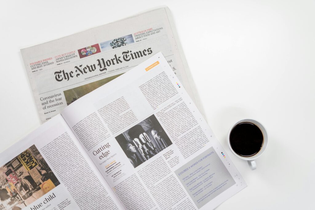 Flat lay of a coffee cup and The New York Times newspaper, ideal for business and lifestyle themes.